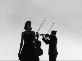 Elizabeth Lawrence holding Viola and Jason Tong holding Violin