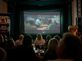 Darkened cinema with film showing and siloettes of audience
