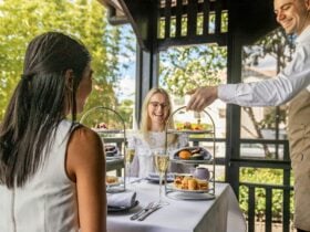 Two high tea stands with sweet and savoury treats being served on a table