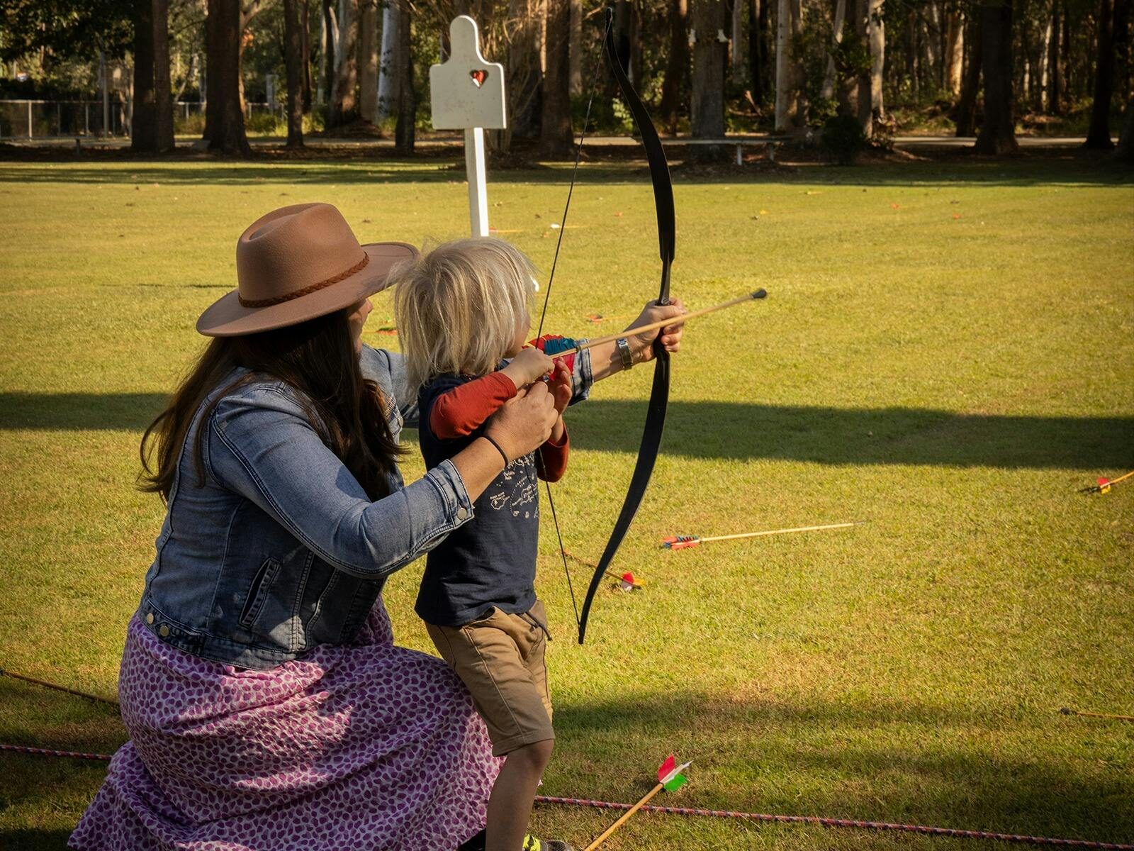 mother and son practicing archery on lawns