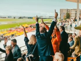 Racing fans celebrate a win in the grandstand.