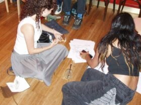 Two people on floor looking at drawings