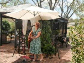 Kodie Sloan singing acoustic songs under an umbrella