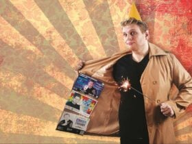 Aaron Ducker stands with a trench coat open displaying flyers from his previous shows