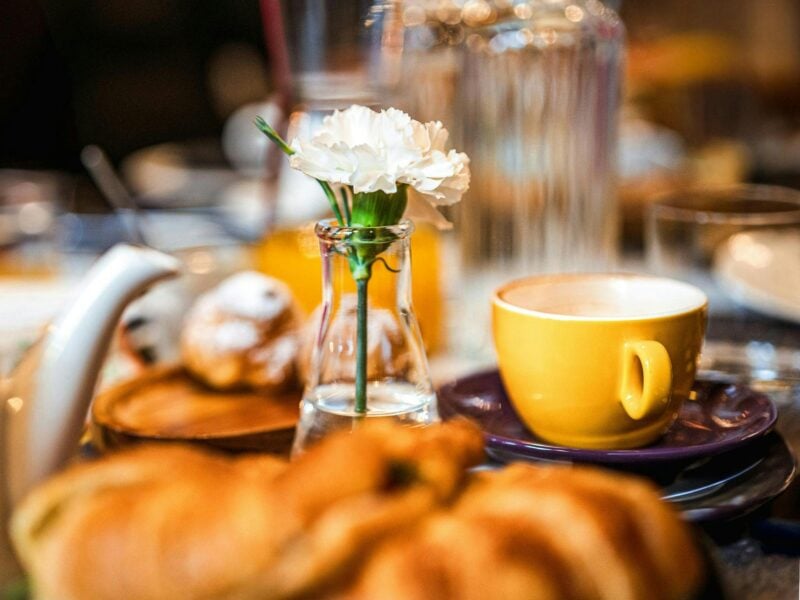 Breakfast table with pastry and flower