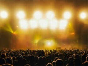 A crowd of people at a music concert, bathed in golden yellow light
