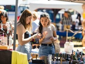 two young women looking at market items