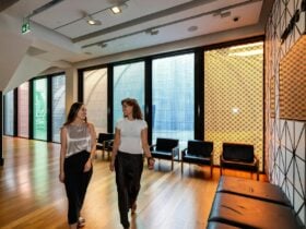 Two women walking through museum foyer smiling