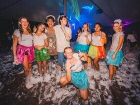 Teenagers laughing and smiling in a sea of foam.