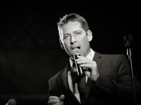 Rhydian Lewis staring longingly into the camera while singing into a microphone