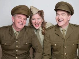 2 men and 1 woman wearing formal khaki military outfits from the 1940s smiling to the camera