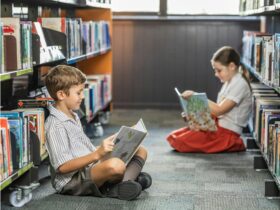 Two children in library reading books