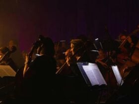 dark orchestra playing with sheet mucis in foreground