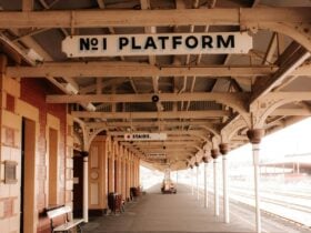 A railway platform, with traditional signage, benches, and brickwork