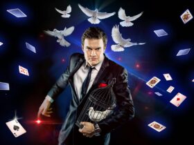 Magician holding birdcage as doves and playing cards float around