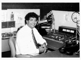 Man with glasses, white shirt and tie in recording studio