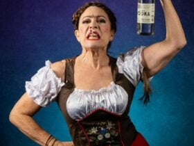 Hairy woman holding up a bottle of vodka. Hair up in braids, angry look and cigarette from mouth