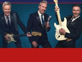 3 Middle aged men with Left and right playing guitar and middle has an old fashion microphone