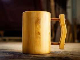 Handcrafted wooden tankard with handle displayed on table.