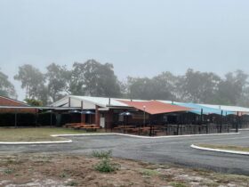 photo showing Burrum Heads Hotel Motel facade with outdoor seating area on a foggy morning