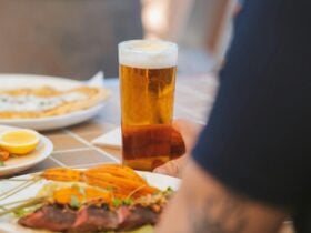 Glass of cold beer on a table with pub meals including steak and seafood in a relaxed dining setting