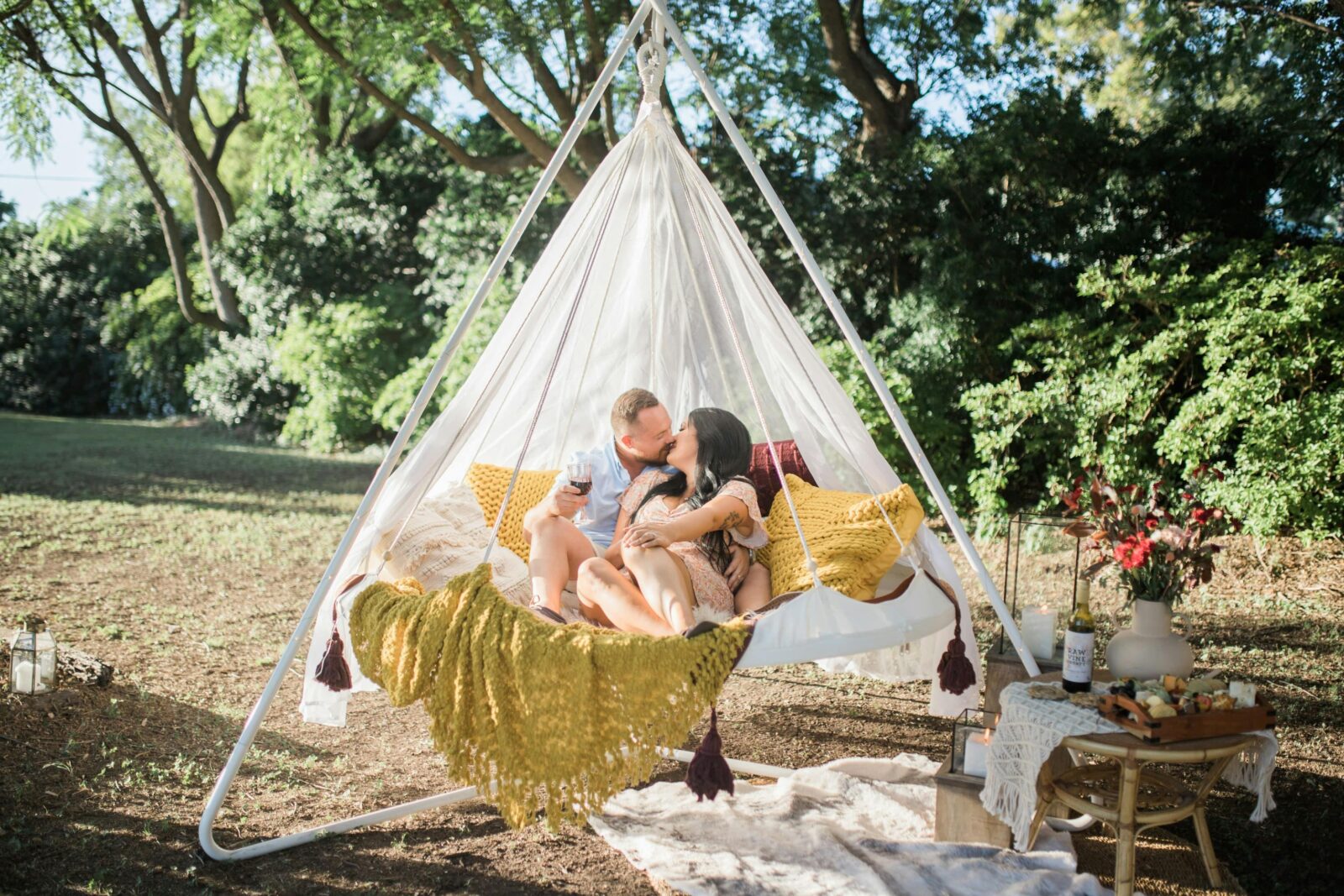 A couple enjoying a romantic picnic in a hanging tiipii pod at Soul Nook
