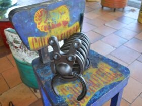 photo of a hand made steel art piece sitting on a tin chair outside Retro Espresso Cafe Tiaor