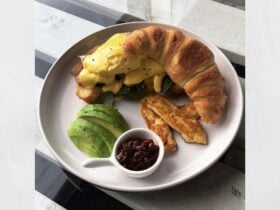 Croissant with bacon, avo, haloumi & chilli jam eggs benny