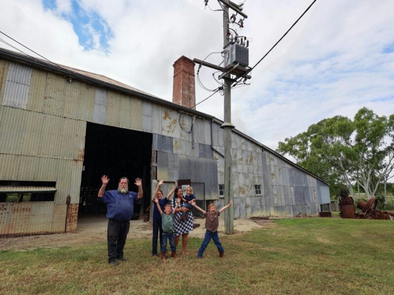 Our tour guide and guests outside the Venus Gold Battery Smiling with hands in the air
