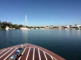 The boat is slowly passing other boats at anchor.