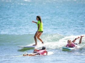 A surfer rides a wave in a group lesson