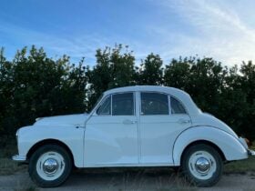 Vintage car parked in apple orchard at sunset