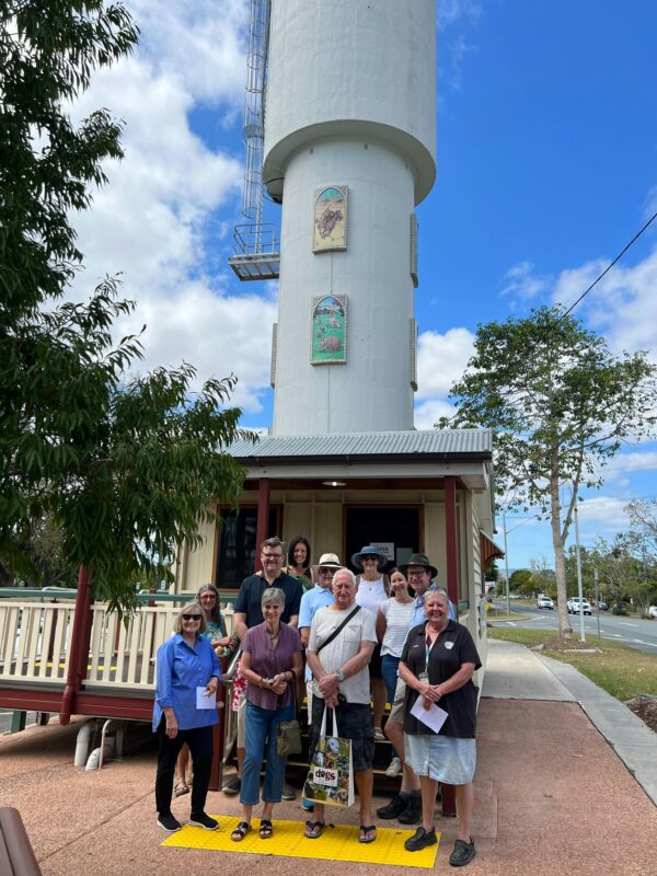 A guide with the walking group tour standing in front of the Woodford Visitor Centre