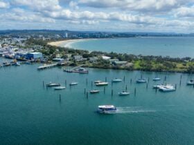 An aerial image of the Mooloolaba Ferry on the water leaving Mooloolaba Beach.