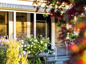 A bluestone home surrounded by gardens