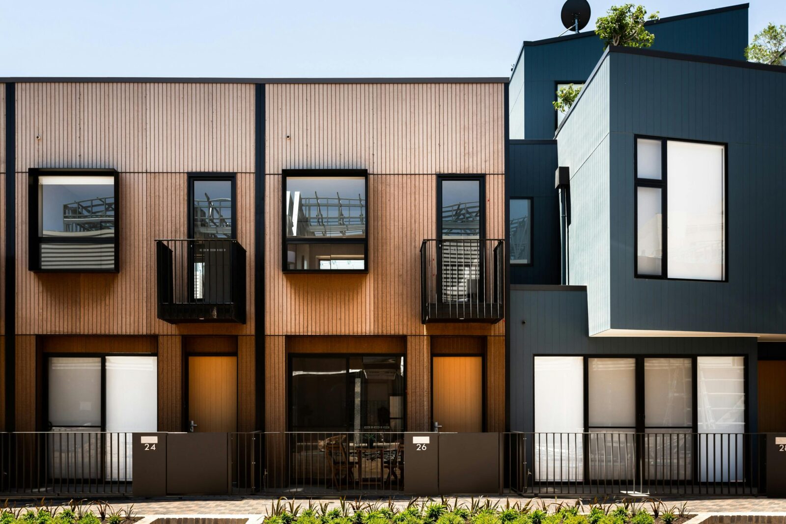 Modern suburban building facade with balconies, on a sunny day.