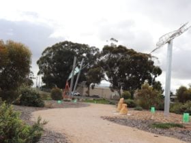 The sculpture is situated in a landscaped garden area.