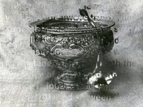 Text is overlaid on a black and white image of an ornate punch bowl and ladle.
