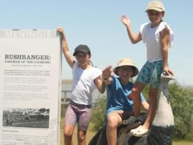 Children pose with the Birdman of the Coorong Ostritch
