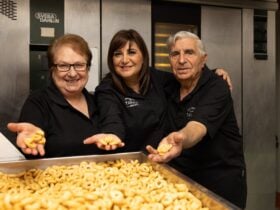 The Bruno family standing behind a large tray of their locally-made savoury biscuits