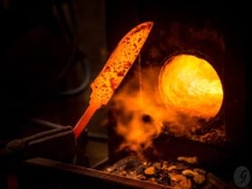 Hand-forged knife being checked by bladesmith.