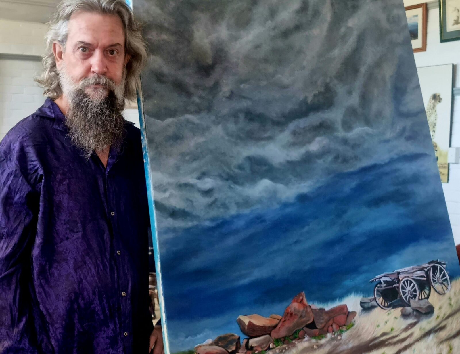 Resident artist John Blackwell standing beside his painting 