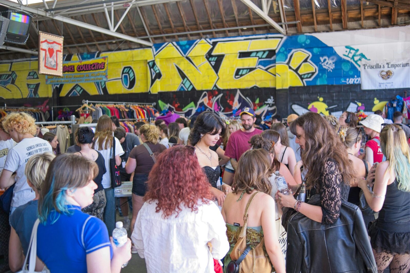 Large crowd shopping vintage under graffiti wall in Adelaideâs coolest warehouse