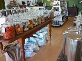 Inside view of Nourish Home & Pantry. Dried fruit filled jars, bags of organic flour flour.