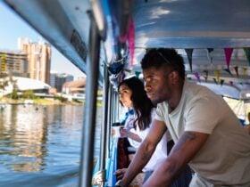 Male and female looking out of the boat to the city of Adelaide