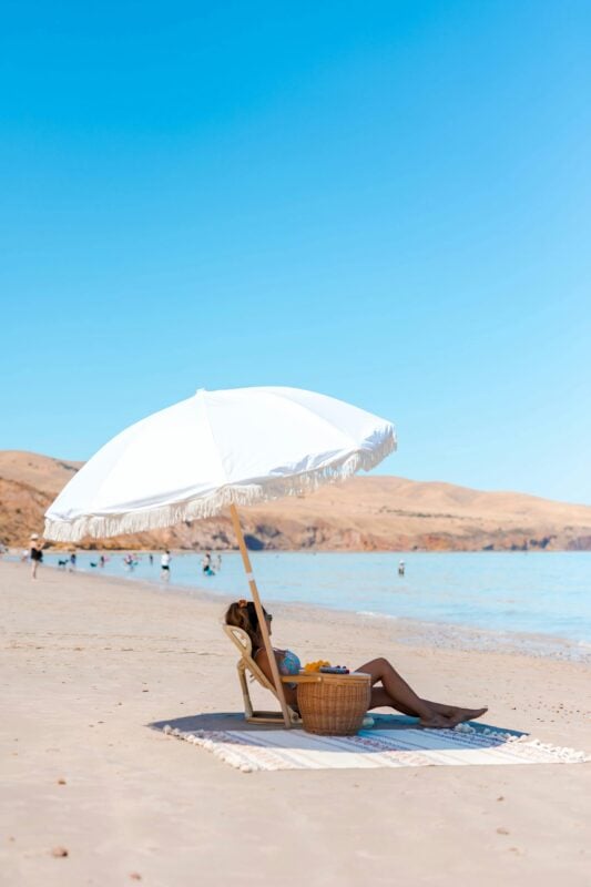 Lady enjoying the beach under umbrella