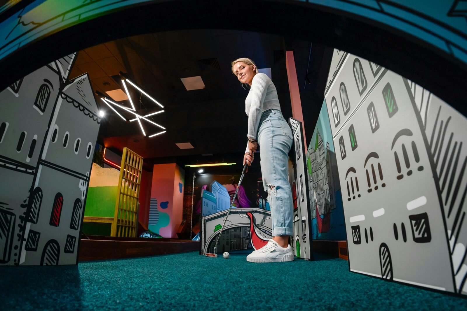 A golfer lining up for a putt on a mini golf course