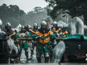 Group of knights in Green and gold livery walking into battle