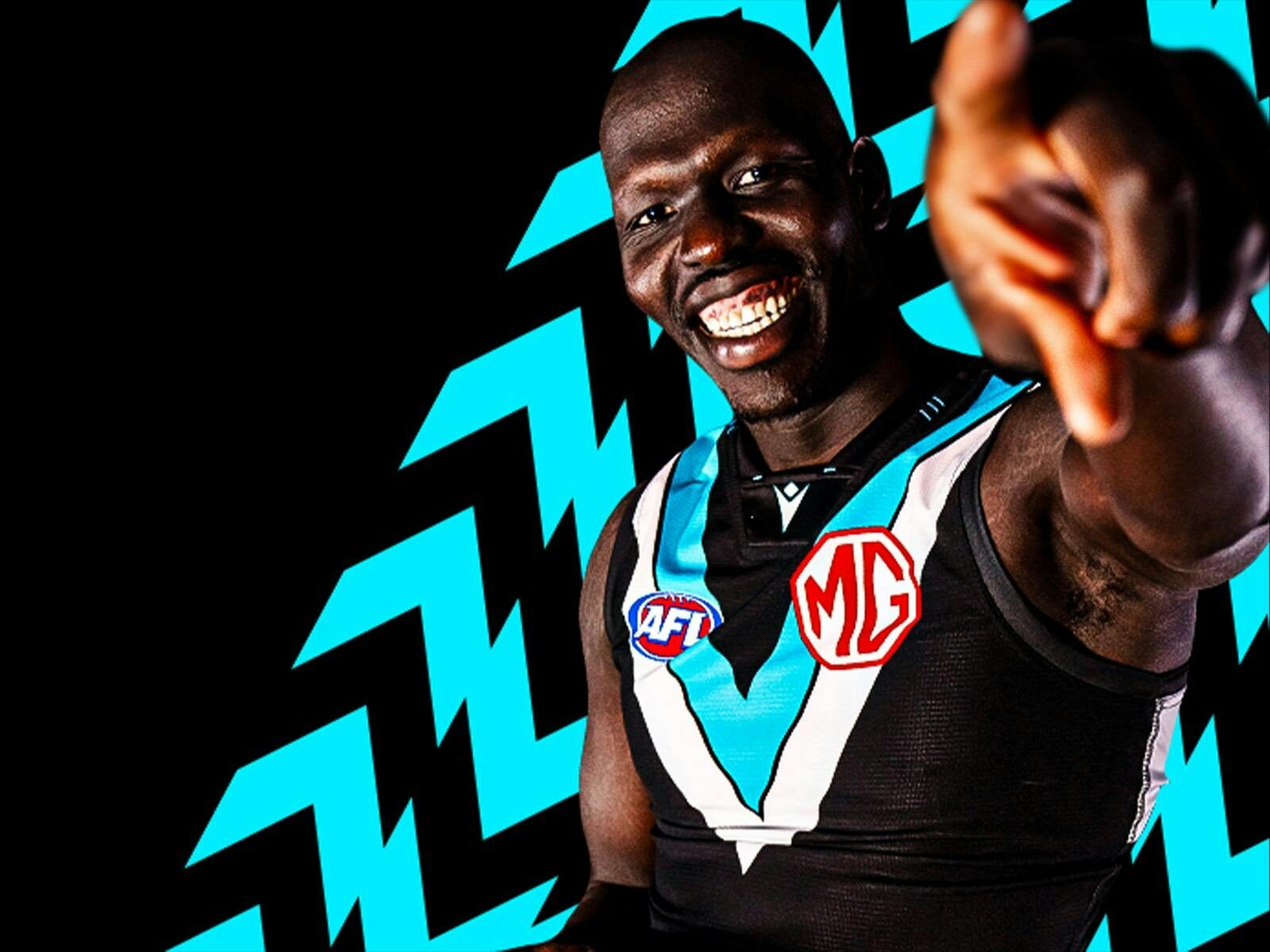 Man standing in front of black and teal arrows pointing towards the camera