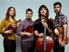 Attacca Quartet standing with their instruments.